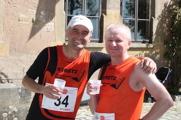 Zwei Läufer mit Getränk in der Hand, nach Zieleinlauf