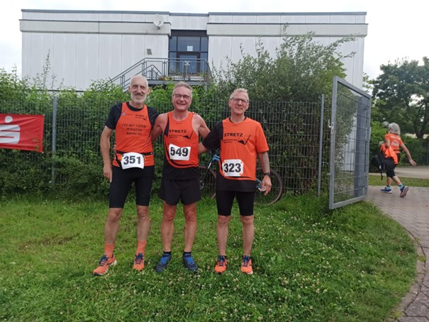 Läufer stehen vor Zaun, Gruppenfoto