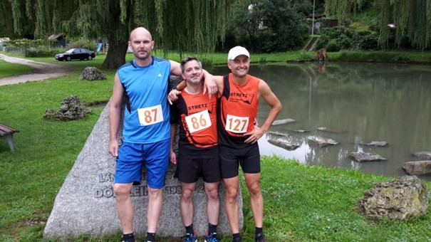 Drei Läufer stehen nebeneinander mit Startnummer