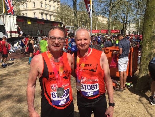 Zwei Läufer mit Medaille um den Hals im Zielbereich