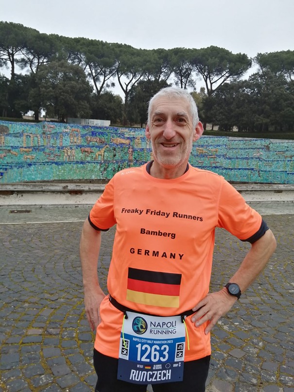 Läufer steht mit Startnummer auf Straße