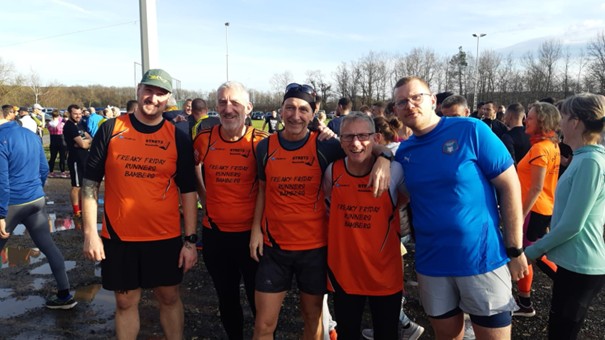 Fünf Läufer posieren zwischen anderen Menschen, Gruppenfoto