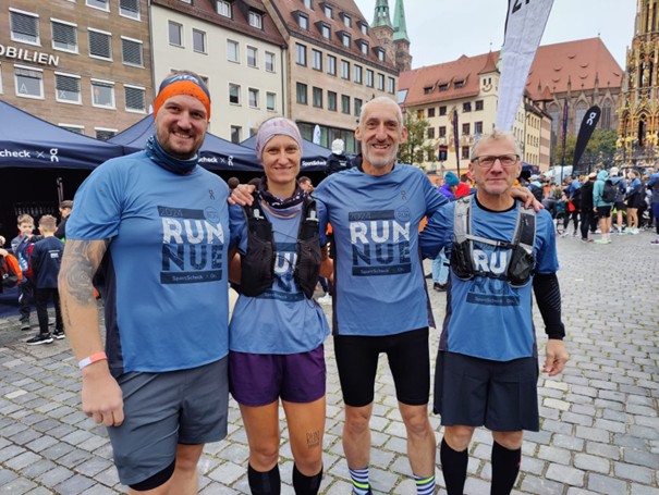 Vier Läufer stehen nebeneinander auf Platz in Nürnberg