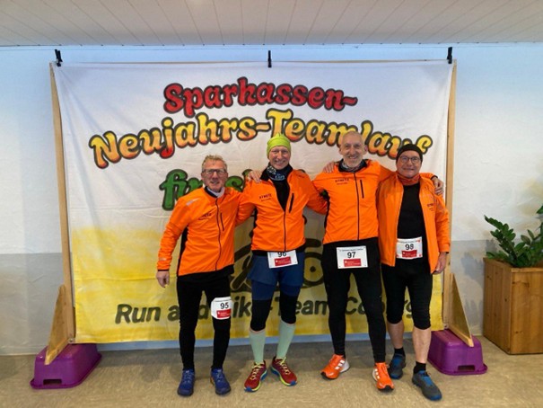 Vier Läufer vor Eventplakat