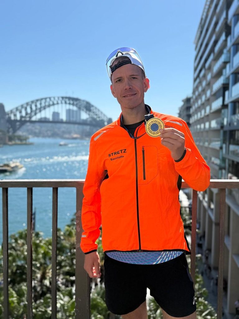 Ein Läufer nach dem Sydney Marathon mit seiner Medailie