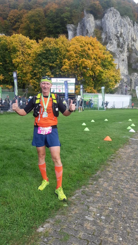 Ein Läufer mit seiner Medaille im Ziel
